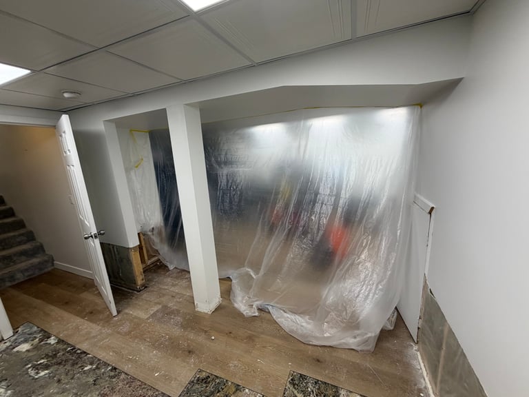Construction area with white plastic sheeting covering doorways and walls in an unfinished interior space